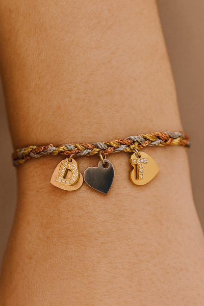 Silver gold and rose gold cord bracelets with gold diamanté initial and 3 tone metal hearts