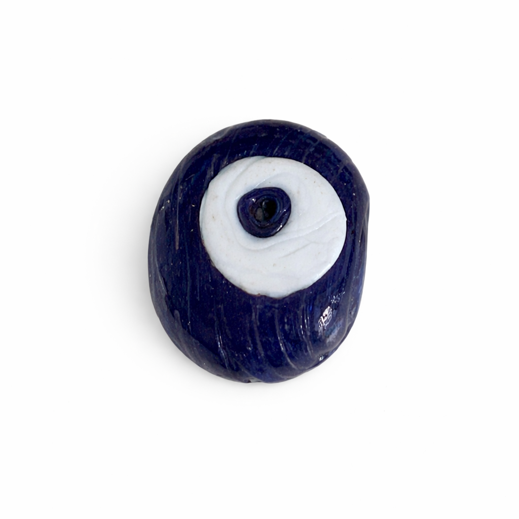 Navy blue evil eye charm on a white background