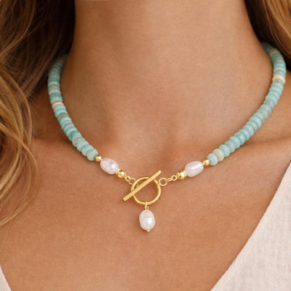 Necklace with turquoise beads and a gold clasp and faux pearl pendant