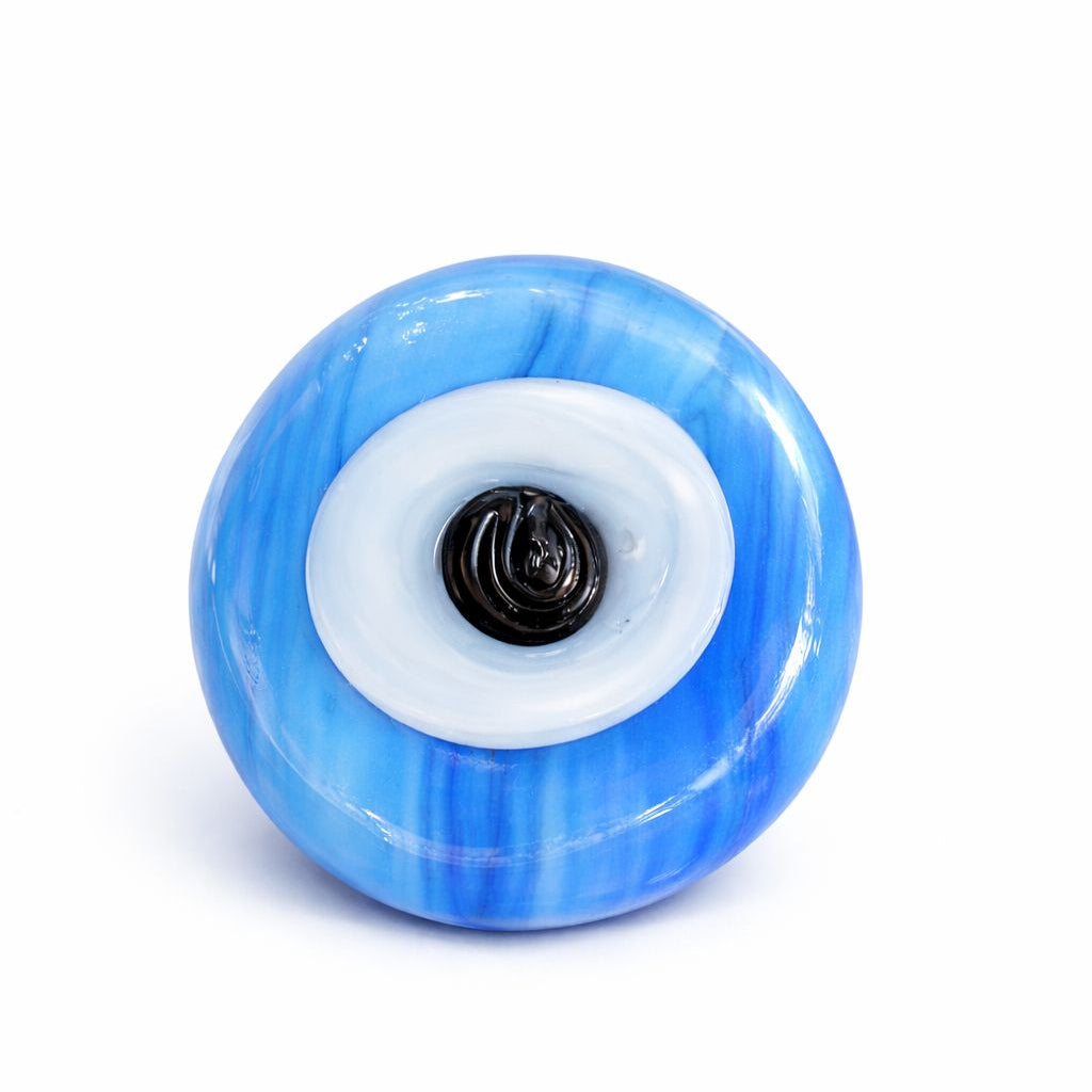 Blue evil eye charm on a white centre
